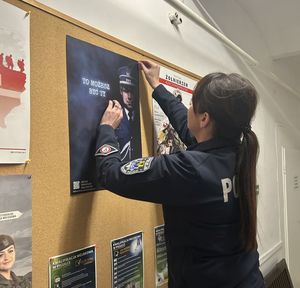 Policjantka wieszająca plakat