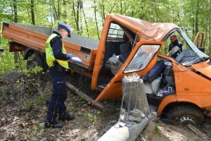 policjant piszący protokół, w tle rozbite auto