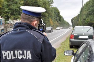 Policjant mierzący prędkosć miernikiem prędkości