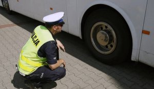 Policjant sprawdza stan techniczny autokaru