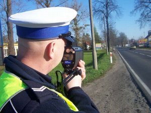 Policjant mierzy urządzeniem predkosc na drodze