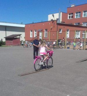 Policjant przeprowadza egzamin na placu na kartę rowerową