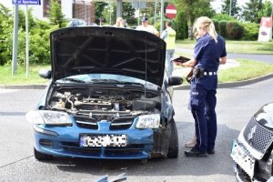 Policjantka sporządza oględziny rozbitego samochodu