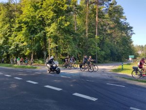 Policjant na motorze asekuruje cyklistów