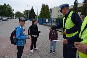 Policjancu rozdają opaski odblaskowe