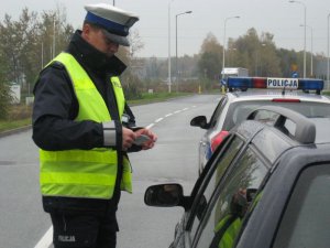 Policjant kontroluję dokumenty kierowcy