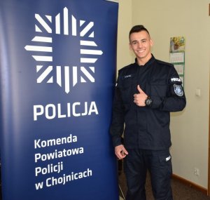 Policjant stoi i trzyma kciuk do góry