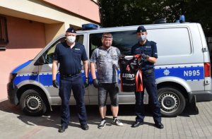 policjanci na tle radiowozu razem z darczyńcą