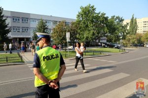 Policjant stoi przy przejściu w okolicach szkoły