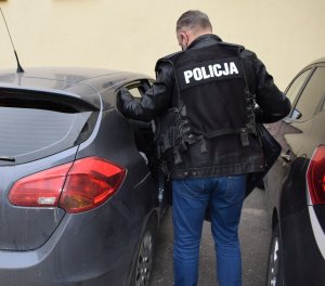 policjant przy nieoznakowanym radiowozie