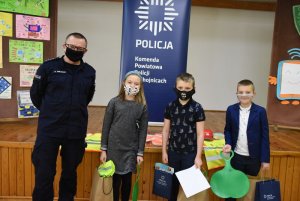 Policjant z trzema uczestnikami konkursu