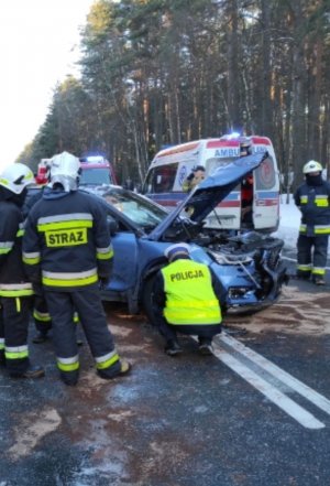 Policjant kuca przy rozbitym pojeździe