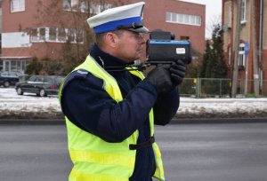 Policjant mierzy prędkość poruszających sie pojazdów