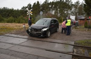 Policjasnt rozmawia ze świadkami przy samochodzie