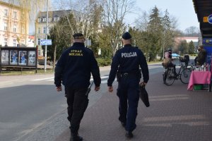 Policjant ze strażnikiem patrlują ciągi komunikacyjne