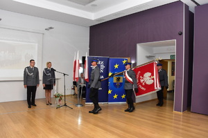 3 policjantów niesie sztandar policji w tle baner policja