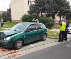 policjant stoi przy rozbitym samochodzie