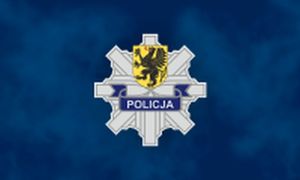 Na niebieskim tle srebrna &amp;quot;gwiazda&amp;quot; odznaka policji z napisem policja