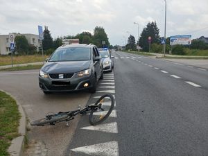 na ulicy leży rower za nim samochód i policyjny radiowóz