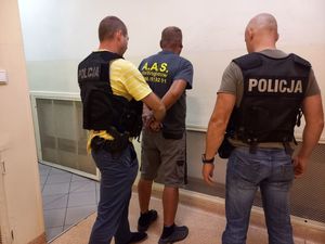 dwóch niemundurowanych policjantów prowadzi zatrzymanego