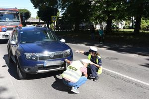 policjantka ruchu drogowego i technik kryminalistyczny robią oględziny samochodu