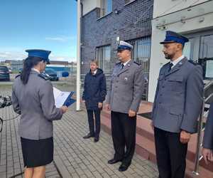 policjantka w mundurze galowym odczytująca podziękowania. w tle 3 policjantów w umundurowaniu galowym policji