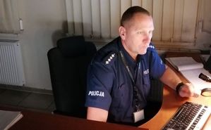 policjant siedzący przy biurku