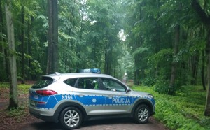 oznakowany radiowóz policji na leśnej drodze