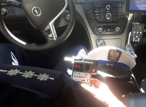 policjant w radiowozie trzymający alkotest