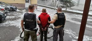 dwoje niemundurowanych policjantów prowadzących osobę zatrzymaną