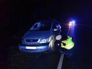 samochód osobowy stojący przy drodze którego sprawdza policjant. samochód po wypadku