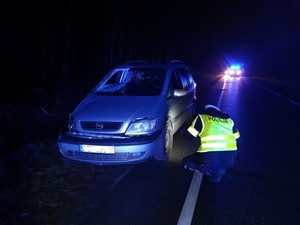 samochód osobowy stojący przy drodze którego sprawdza policjant. samochód po wypadku