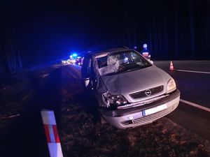 samochód osobowy stojący przy drodze którego sprawdza policjant. samochód po wypadku