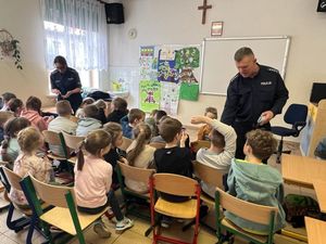 policjant rozmawiający z dziećmi w klasie szkolnej