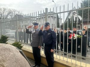 Policjanci stojący przed upamiętniającym obeliskiem