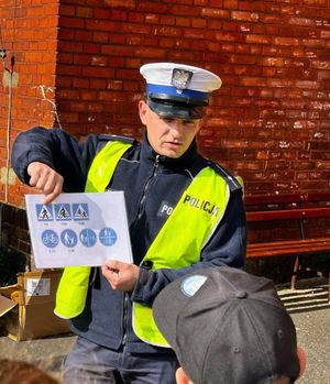 policjant pokazujący dzieciom znaki drogowe