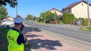 Policjant stojący przy ulicy który mierzy prędkość