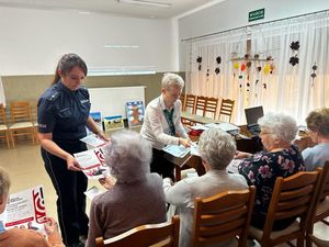 Policjantka rozdająca ulotki seniorom