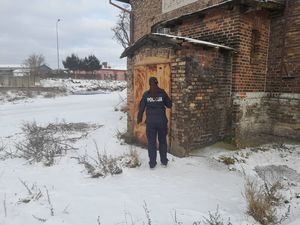 Policjant stojący przy budynku z czerwonej cegły