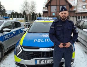 Policjant stojący przy radiowozie