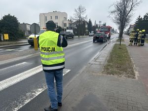 Policyjny technik kryminalistyki wykonujący zdjęcia na miejscu zdarzenia.