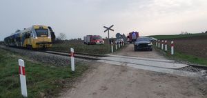 Samochód stojący przy przejeździe kolejowym za min wóz strażacki