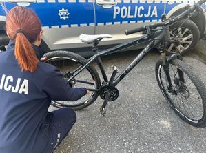 Na zdjęciu rower na tle radiowozu. Trzyma go policjantka