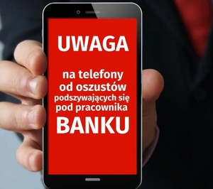 Telefon z widocznym ekranem, na którym znajduje się czerwone tło i czarnymi napisami