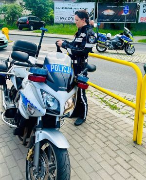 Policjantka stojąca przed policyjnym motocyklem