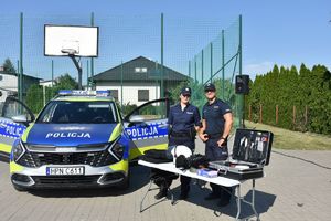 Promocja zawodu policjant podczas pikniku na placu zabawa.