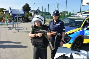 Promocja zawodu policjant podczas pikniku na placu zabawa.