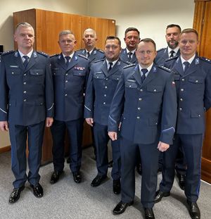 Grupa policjantów w umundurowaniu galowym stojąca w szeregu