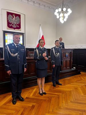 Policjanci oraz cywile stojący obok siebie w auli starostwa Powiatowego