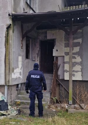 Policjant stojący przed schodami do budynku